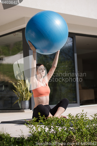 Image of woman doing exercise with pilates ball