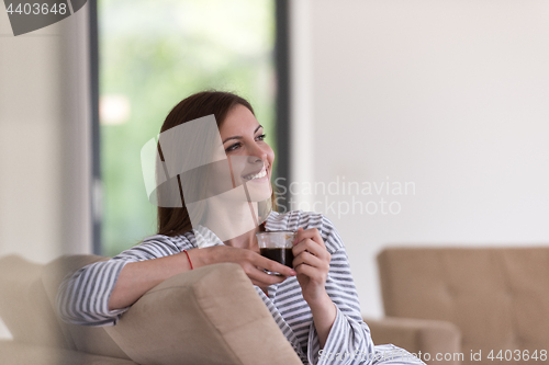 Image of young woman in a bathrobe enjoying morning coffee