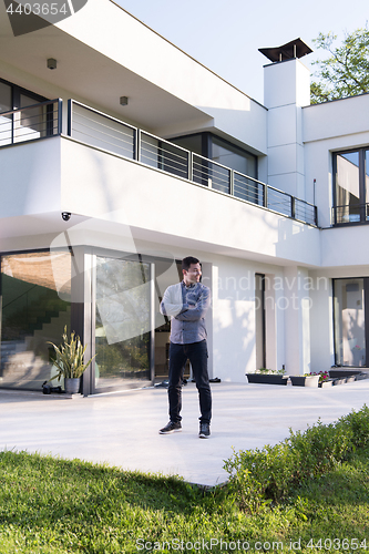 Image of man in front of his luxury home villa