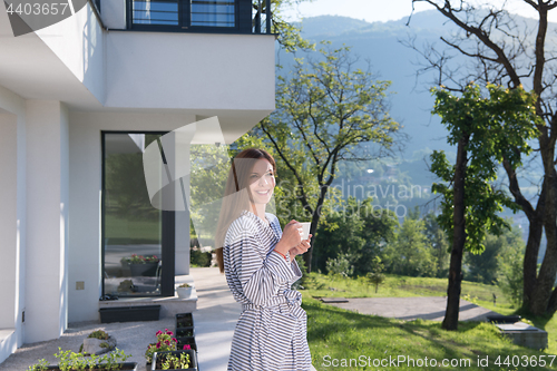 Image of woman in a bathrobe enjoying morning coffee