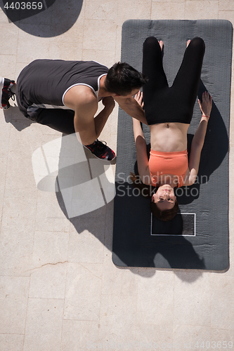 Image of woman with personal trainer doing morning yoga exercises top vie