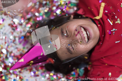 Image of kid blowing confetti while lying on the floor