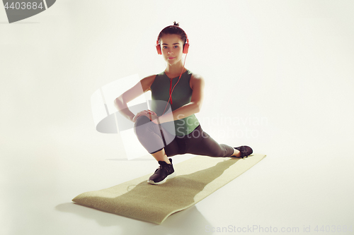 Image of Front view of a young woman stretching body in gymnastics class.