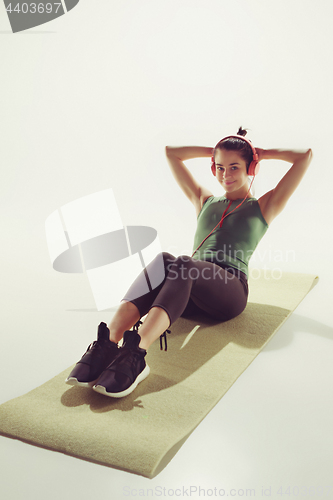 Image of Front view of a young woman stretching body in gymnastics class.