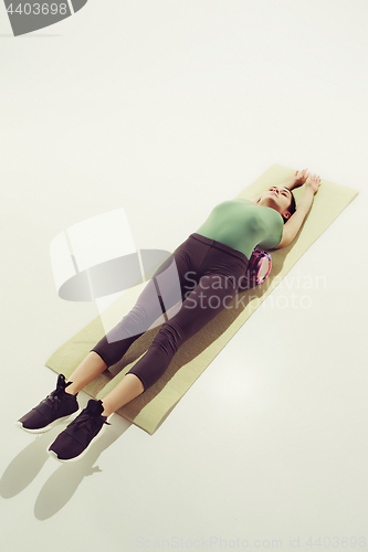 Image of Front view of a young woman stretching body in gymnastics class.