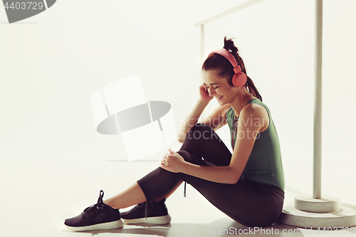 Image of Front view of a young woman sitting with headphones