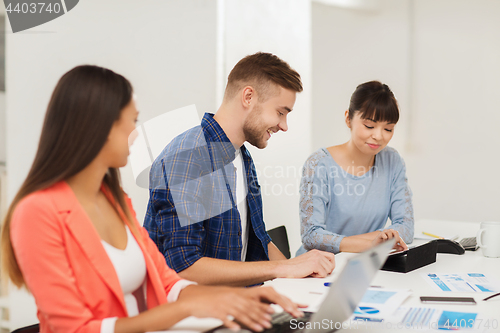Image of happy creative team or students working at office