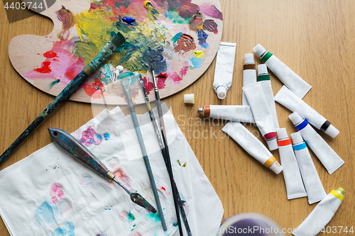 Image of palette knife, brushes and paint tubes on table