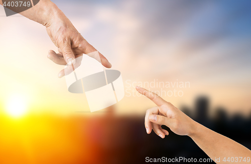 Image of close up of senior and young woman hands