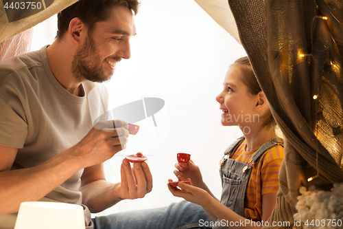 Image of family playing tea party in kids tent at home