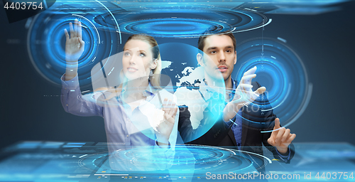 Image of businessman and businesswoman with virtual earth