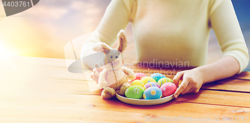 Image of close up of woman hands with easter eggs and bunny