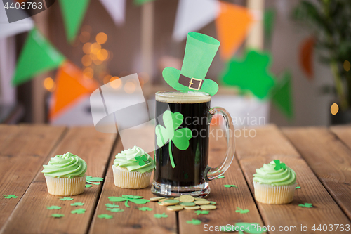 Image of shamrock on glass of beer, green cupcakes and coins