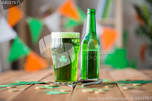 Image of glass of green beer with shamrock and horseshoe