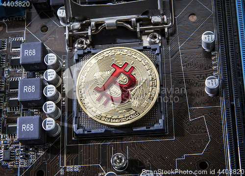 Image of Gold Bit Coin BTC coins on the motherboard. Bitcoin is a worldwi