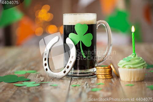 Image of glass of beer, horseshoe, green cupcake and coins