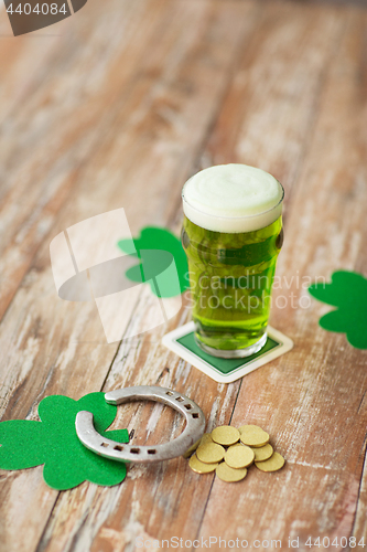 Image of glass of green beer, horseshoe and gold coins