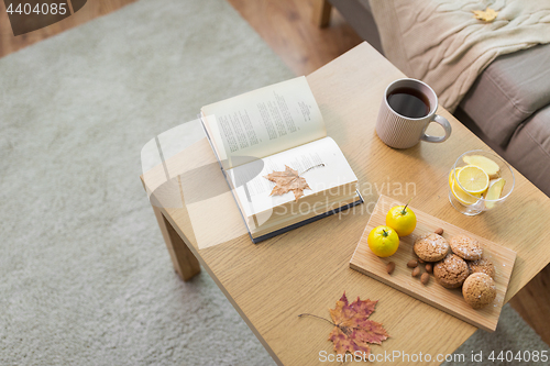 Image of book, lemon, tea and cookies on table at home