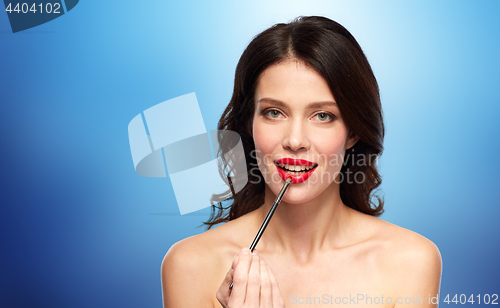 Image of beautiful woman with make up brush for lipstick