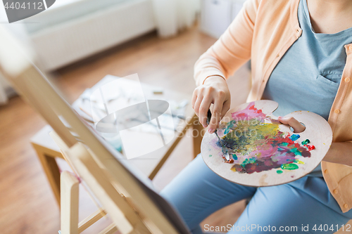 Image of artist with palette knife painting at art studio