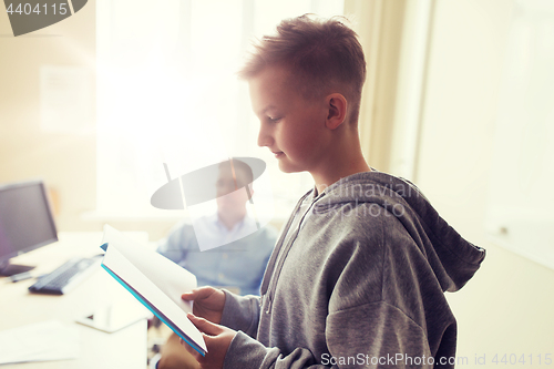 Image of student boy with notebook and teacher at school