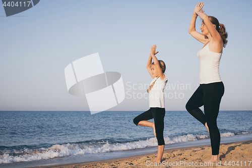 Image of Happy family standing on the beach at the day time.