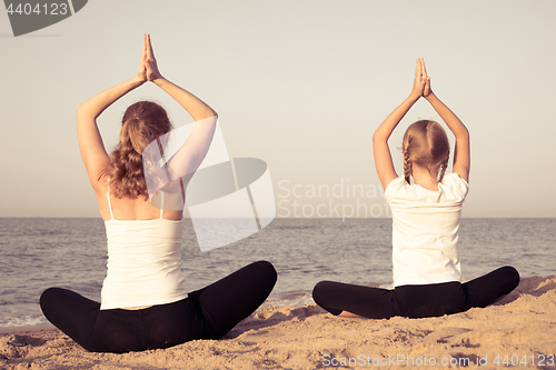 Image of Happy family standing on the beach at the day time.