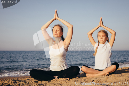 Image of Happy family standing on the beach at the day time.