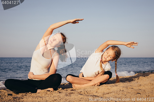 Image of Happy family standing on the beach at the day time.