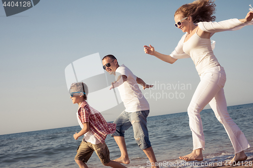 Image of Happy family running on the beach at the day time.