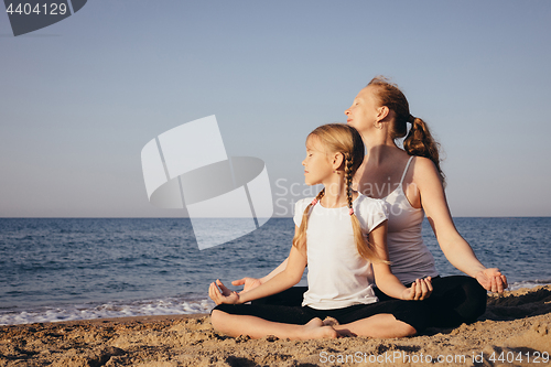 Image of Happy family standing on the beach at the day time.