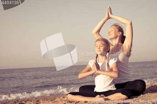 Image of Happy family standing on the beach at the day time.