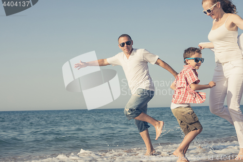 Image of Happy family running on the beach at the day time. 