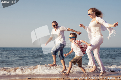 Image of Happy family running on the beach at the day time.