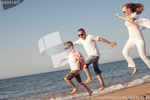 Image of Happy family running on the beach at the day time.