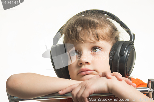 Image of Portrait of a girl in headphones listening to music musically