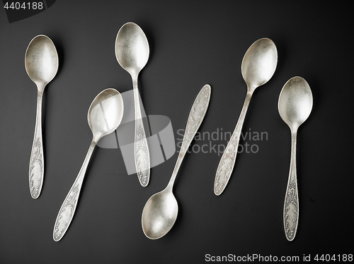 Image of old silver spoons on black background