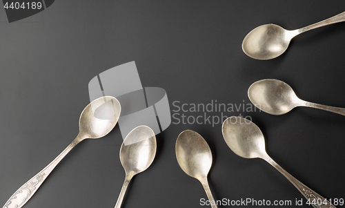 Image of old silver spoons on black background