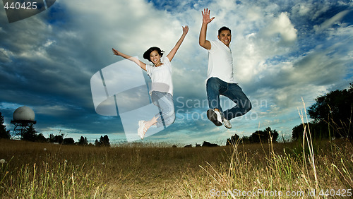 Image of Asian couple jumping in joy