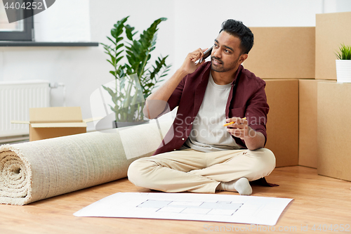 Image of man with blueprint and boxes moving to new home