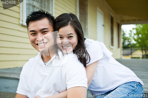 Image of Asian couple in front of their house