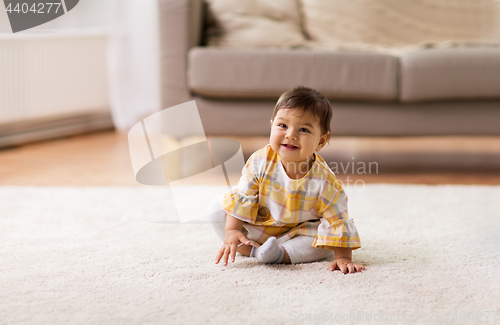 Image of happy smiling baby girl sitting on floor home