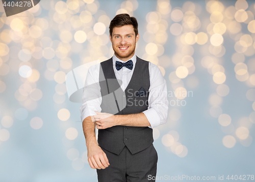 Image of happy man in festive suit dressing for party