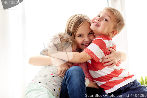 Image of happy little kids hugging at window