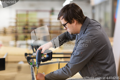 Image of assembler with screwdriver making furniture