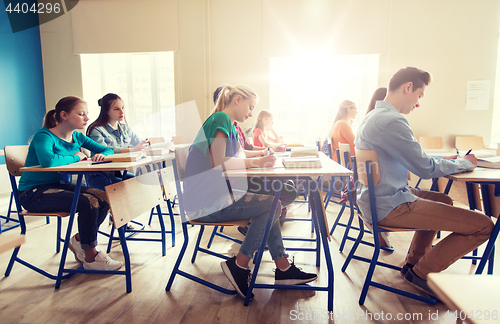 Image of group of students with books writing school test