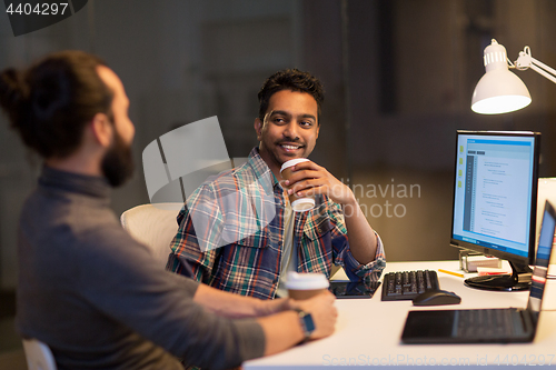 Image of creative team drinking coffee at night office