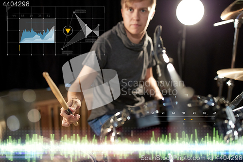 Image of male musician playing drum kit at concert