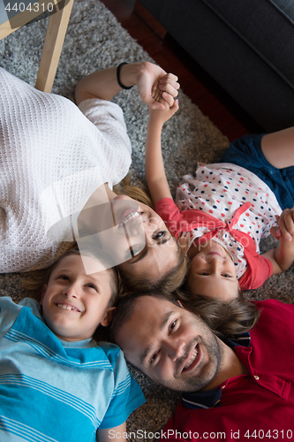 Image of happy family lying on the floor