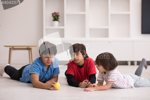 Image of boys having fun with an apple on the floor